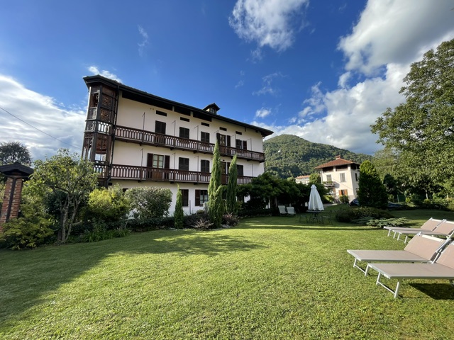 Vista d'insieme della dimora con ampio giardino e vista sulle montagne