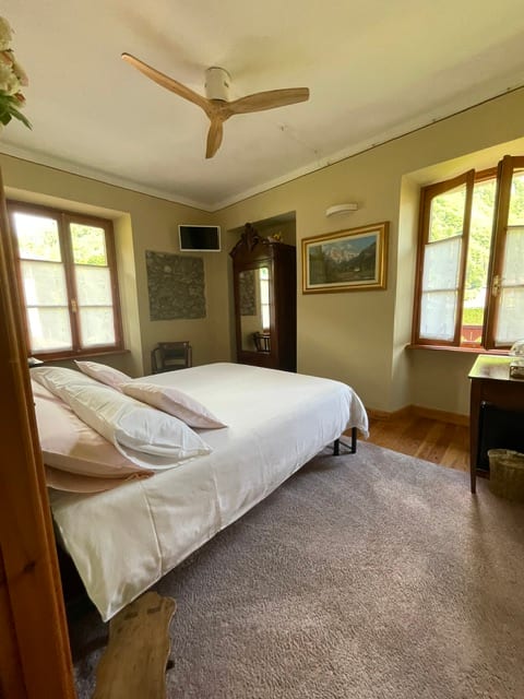 Camera da letto luminosa con letto matrimoniale e vista giardino